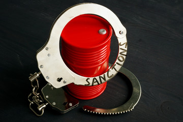 Trade embargo and sanctions concept. Barrel of oil and handcuffs.
