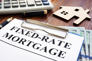 Fixed rate mortgage, wooden home and calculator.