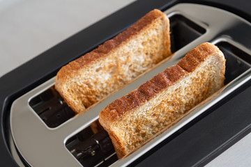 Healthy fashion food of breakfast. Toast in a toaster. Toaster with tasty breakfast toasts on the table
