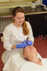 Young beautiful woman receiving facial massage and spa treatment in beauty salon