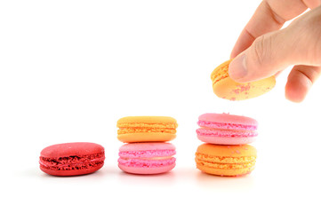 Male hand putting Macaroon stack growing up,Grow concept background, food concept on white background.
