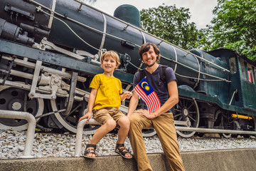 Father and son travelers in malaysia with malaysia flag celebrating the Malaysia independence day...