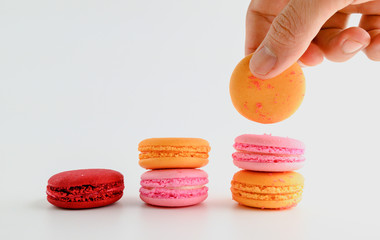 Male hand putting Macaroon stack growing up,Grow concept background, food concept on white background.
