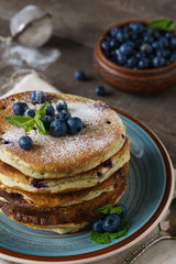 Pancakes with blueberries, mint and powdered sugar.