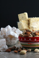 A mug of coffee and different oriental sweets: turkish delight, halva, almond and pistachio