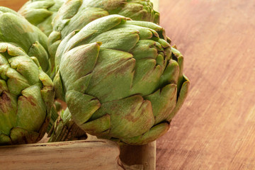 Obraz premium A closeup of a globe artichoke on a rustic wooden background with copy space