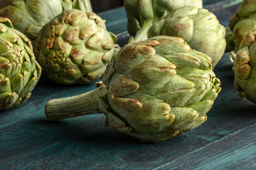 A closeup of a globe artichoke on a rustic wooden background