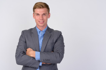 Happy young handsome businessman with arms crossed