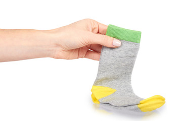 Hand with warm winter childrens socks, cute cotton clothes