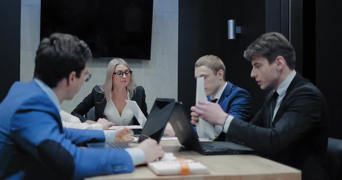 Boss scolds the employee at the meeting. Partners discuss the company's strategy.