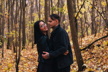 The girl and the guy are walking in the autumn forest