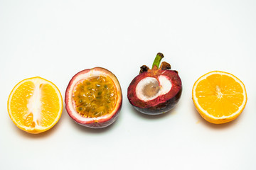 sliced in half tropical fruits on a white background
