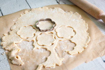 Flower shaped cookie cutter cutting out sugar cookies