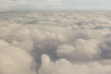 Layer of clouds taken from aircraft above scene illuminated by low evening or morning sun rays of warm golden color. Easy background photography of simple composition and empty space.