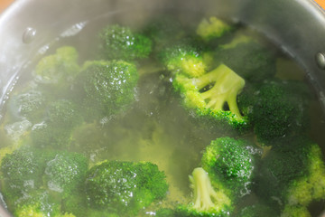 Broccoli into saucepan in boiling water, close-up view