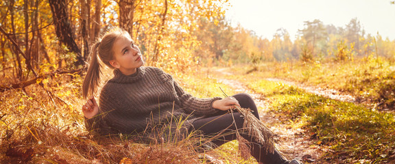 Yellow leaves above the lake. Autumn landscape. Young tourist woman on the beach in the crystal clear water, tourism, travel,hugge,lagom. Long banner