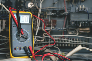 A multimeter on a electric switchboard background. Electric work concept background.