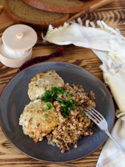 Buckwheat with meatballs pickled greens on a plate on a wooden background