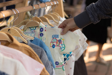 Kinderkleidung auf einer Kleiderstange auf einem Bio-Markt