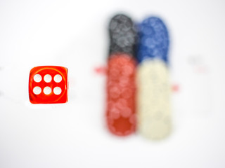 Close-up cube and poker chips in the background.