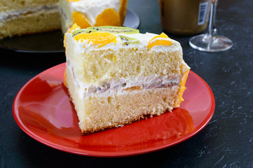 Big piece fruit sponge cake on a black background.  Festive cake.