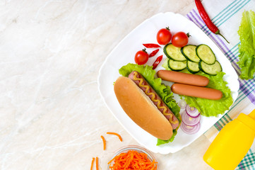 Tasty hot dogs with sausage grill, ketchup, mustard, lettuce, tomatoes on a white plate. The top view. Flat lay