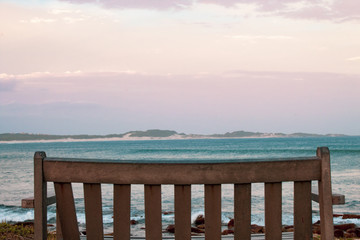 A lonely wooden bench overlooking the south african wavy ocean; peace of mind concept