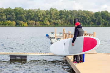 Surfer in warm clothes going to surfing