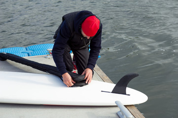 Unrecognizable athlete packing his water sports equipment