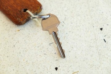 Metal Key and Wooden Keychain on the Terrazzo Table