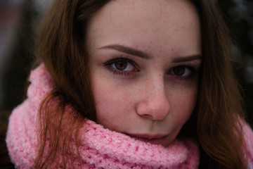 Portrait of a woman in a woolen scarf in winter outside