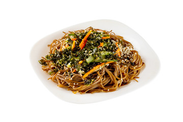 Closeup plate of buckwheat noodles with vegetables salad isolated at white background.