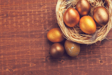 Gold Easter eggs on wooden background