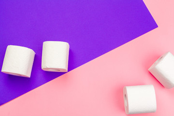 White toilet paper rolls on bright color block background