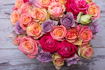 Beautiful bouquet of roses in a gift box. Bouquet of pink roses. Pink roses close-up. on wooden background, with space for text.