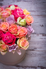 Beautiful bouquet of roses in a gift box. Bouquet of pink roses. Pink roses close-up. on wooden background, with space for text.