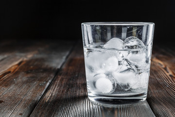 Vodka in shot glasses on rustic wood background