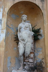 Abandoned feminine statue in a garden somewhere in Italy