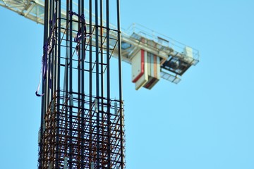 Concrete pillars on construction site. Building of skyscraper with crane, tools and reinforced...
