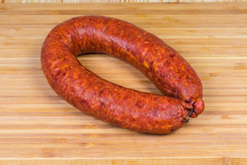 Ring pork bologna sausage on a wooden cutting board
