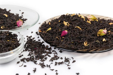 Tea leaves with chinese rose buds on saucers close-up