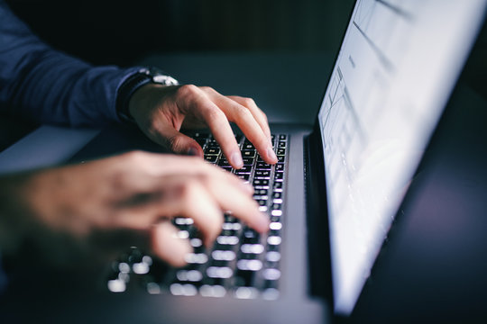 Close Up Of Hands Typing On Laptop. Night Work Concept.