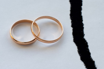 wedding rings on white paper and black background.