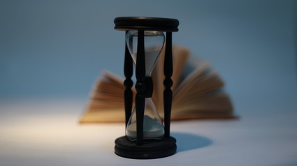open book and hourglass.isolated on a yellow background