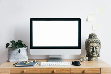 Stylish scandinavian interior of home creative desk with mock up computer screen, plants, bookstand...