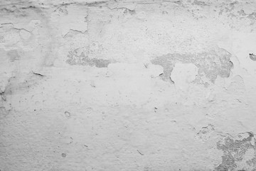 grey concrete wall grunge texture with cracks.  peeling old paint and plaster on background of old cement wall. 