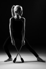 Teenager girl involved in rhythmic gymnastics. Black background