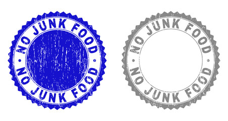 Grunge NO JUNK FOOD stamp seals isolated on a white background. Rosette seals with distress texture in blue and grey colors. Vector rubber stamp imitation of NO JUNK FOOD text inside round rosette.