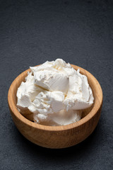 Traditional Mascarpone cheese in wooden bowl on concrete background