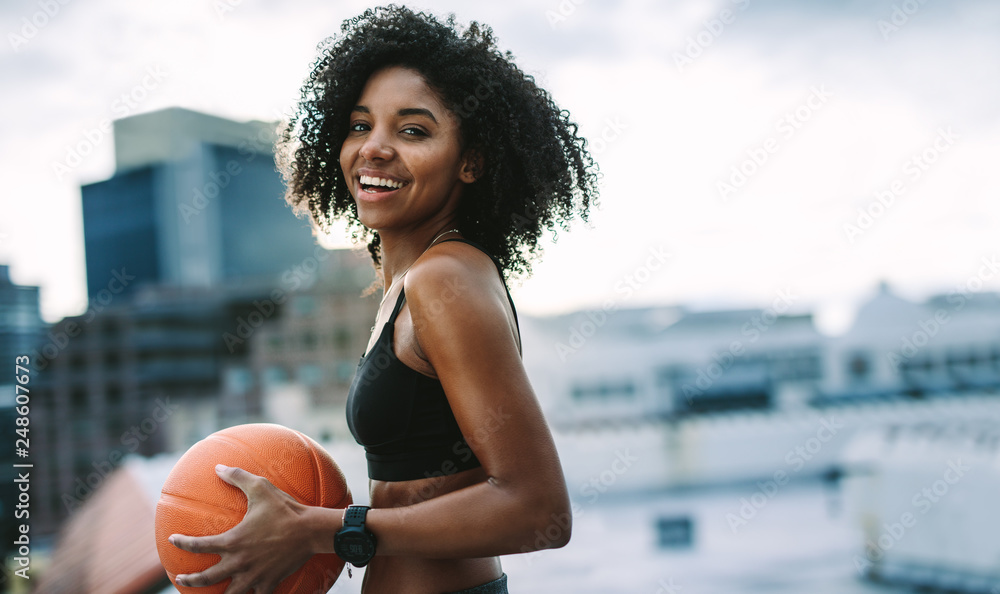 Wall mural Portrait of a fitness woman holding a basketball - Wall murals